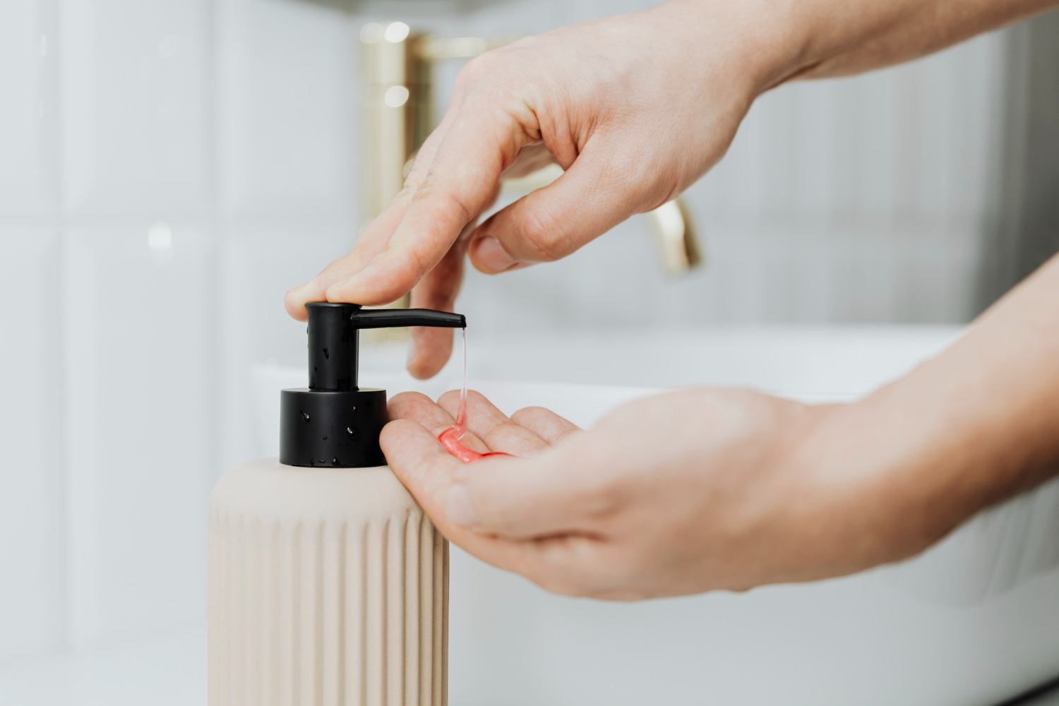 Person dispensing body wash from an unbranded pump bottle