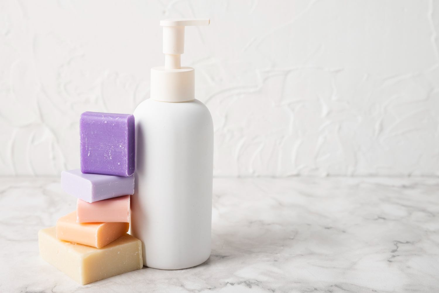 Unbranded pump bottle displayed beside several bars of soap