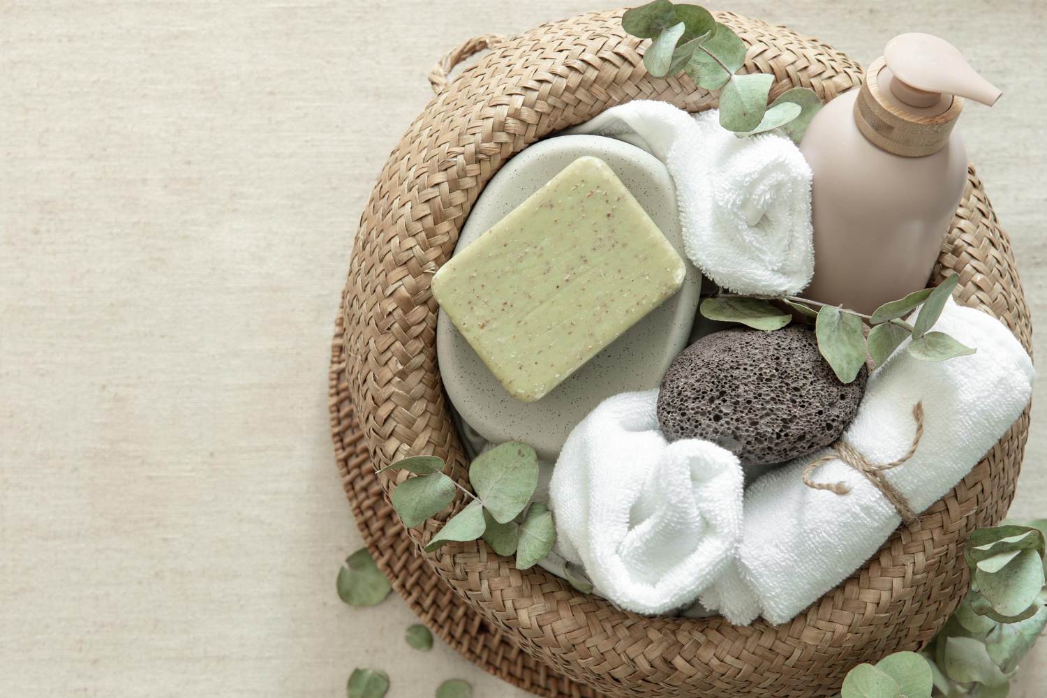 Unbranded body wash, soap, towels, and eucalyptus leaves