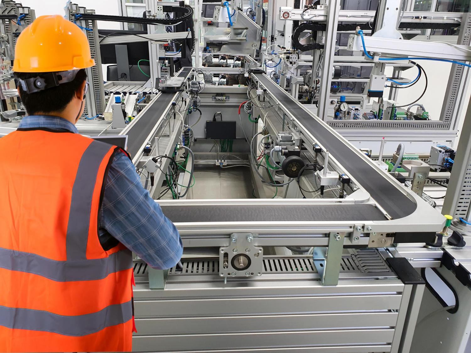 Engineer monitoring automated equipment on a manufacturing production line