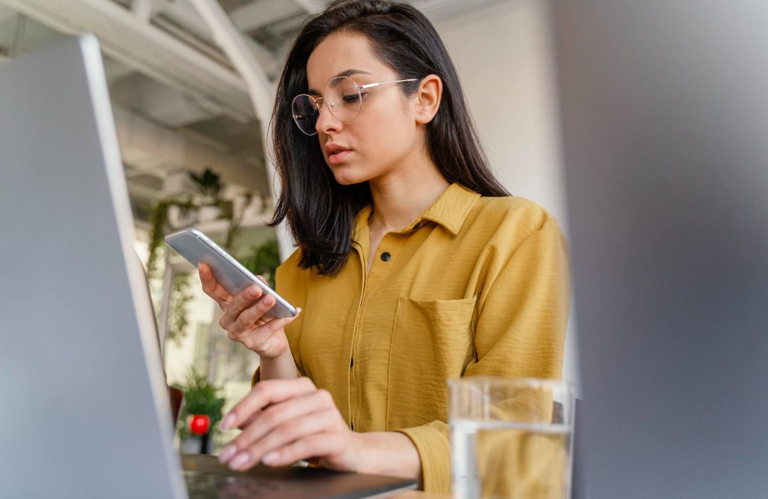 Professional comparing information on a smartphone and desktop computer