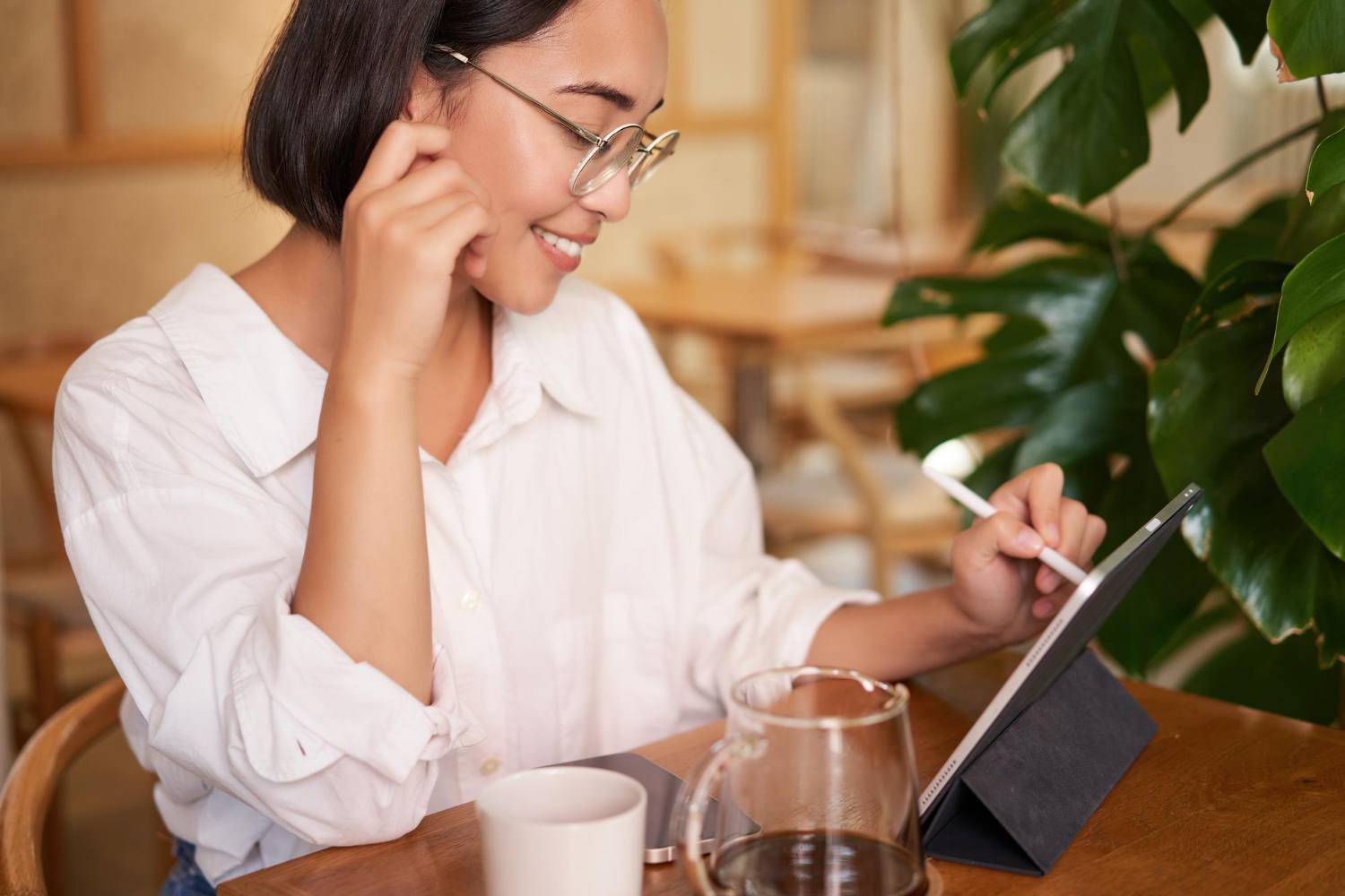 Content planner writing on a tablet at a cafe table