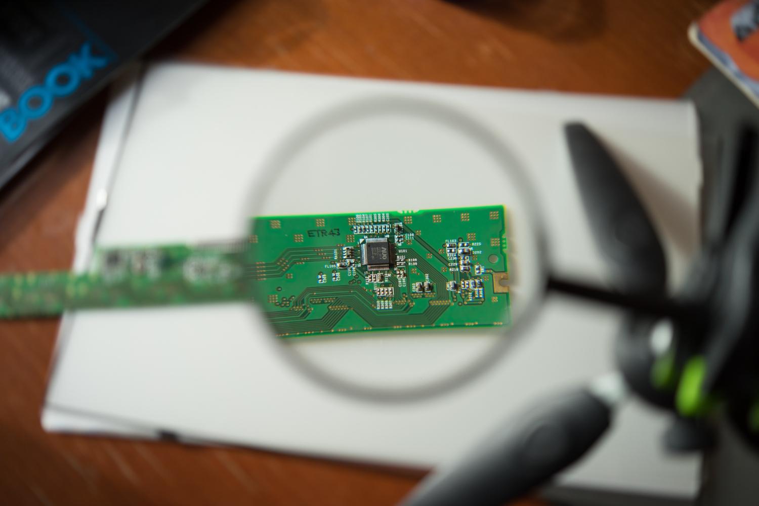 Printed circuit board examined through a magnifying lens