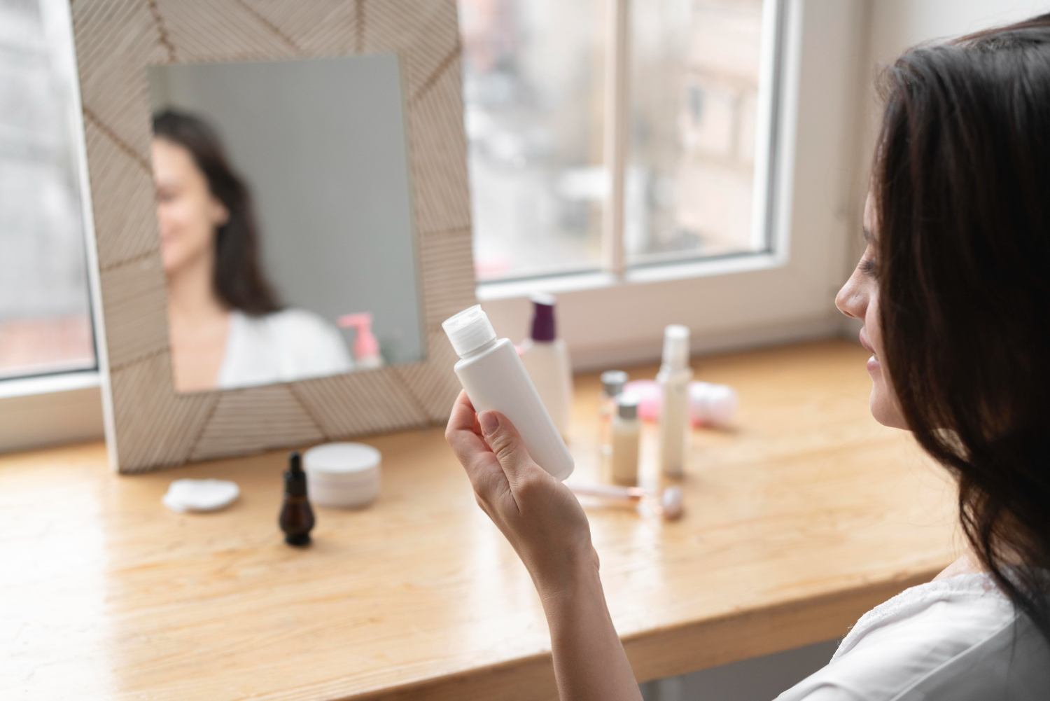 Person reading the label on an unbranded personal care bottle
