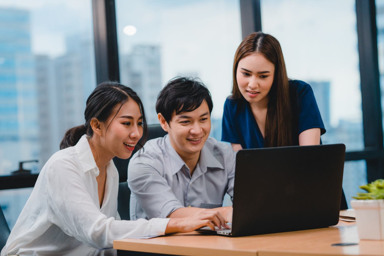 Business team collaborating around a laptop